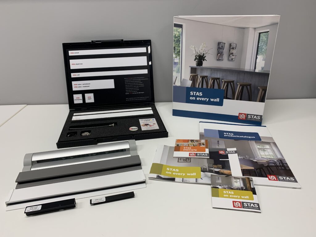 De STAS-dealerset van Heijnen Decor met railprofielen, koorden, haken en productcatalogi op tafel