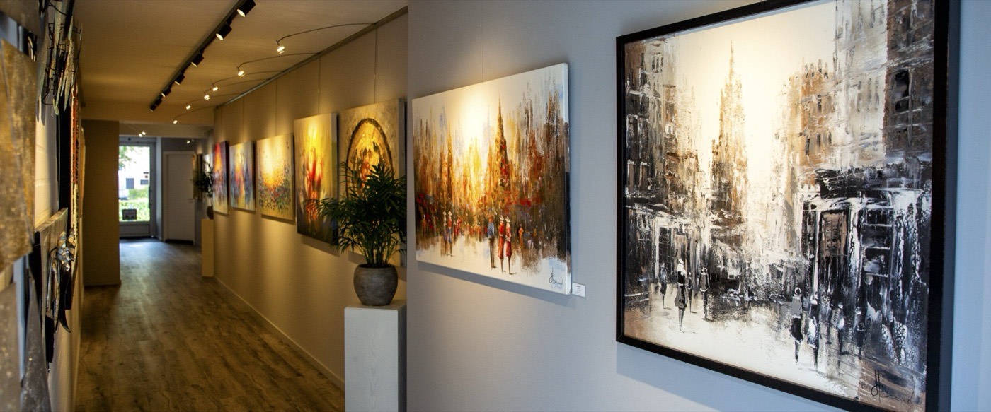 De galerie van Heijnen Decor in Nederweert-Eind: een gang met ingelijste schilderijen aan de wand onder museumverlichting