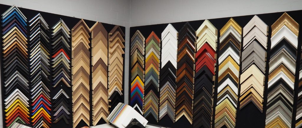 Een wand met ingelijst werk in het atelier van Heijnen Decor in Nederweert-Eind